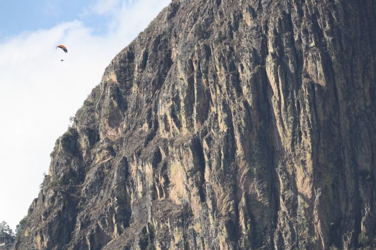 El Penon cliff face with a paraglider above